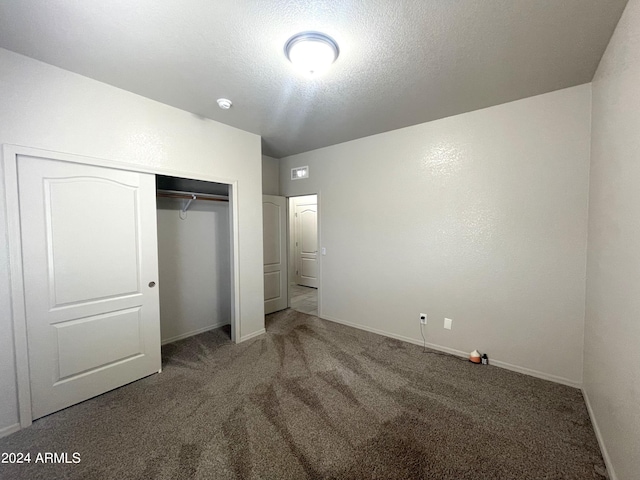 unfurnished bedroom with a closet, carpet floors, and a textured ceiling