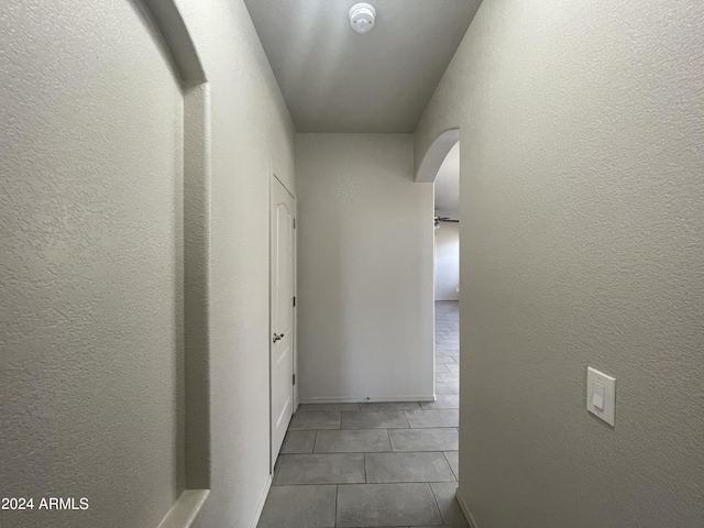 corridor featuring dark tile patterned flooring