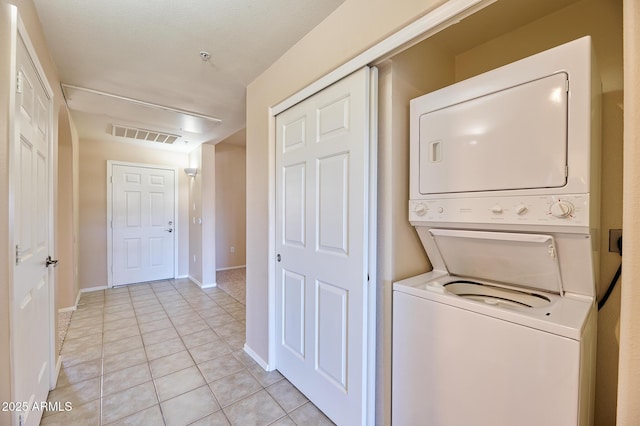 laundry area featuring light tile patterned floors, laundry area, visible vents, baseboards, and stacked washer / dryer