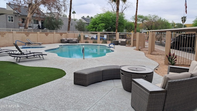 community pool with outdoor lounge area, fence, and a patio area