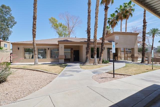 view of front of property featuring stucco siding and fence