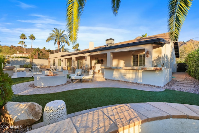 back of house featuring a patio area, ceiling fan, and a fire pit