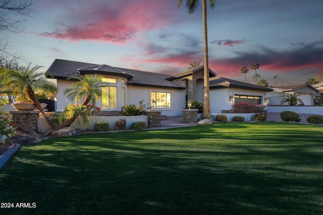 view of front of house with a garage and a lawn