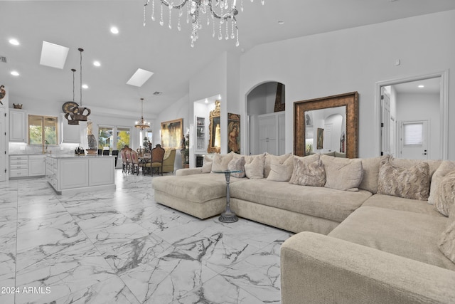 living room with a skylight, sink, high vaulted ceiling, and a chandelier