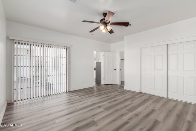 unfurnished bedroom with ceiling fan, light wood-type flooring, and a closet