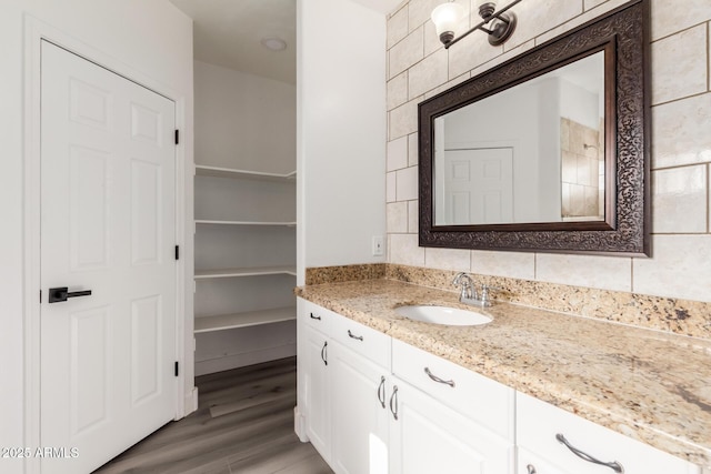 bathroom with decorative backsplash, hardwood / wood-style floors, and vanity