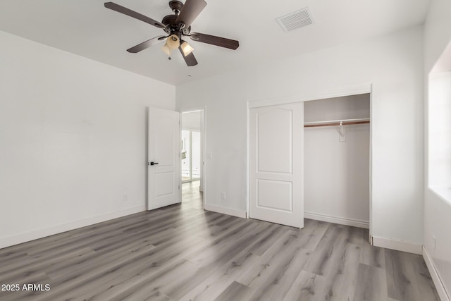 unfurnished bedroom with a closet, light hardwood / wood-style floors, and ceiling fan