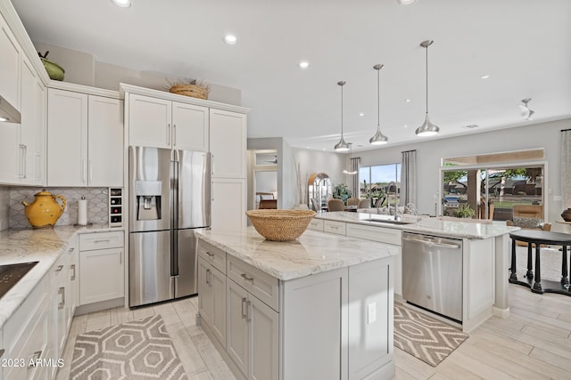 kitchen with tasteful backsplash, stainless steel appliances, a center island, and white cabinets