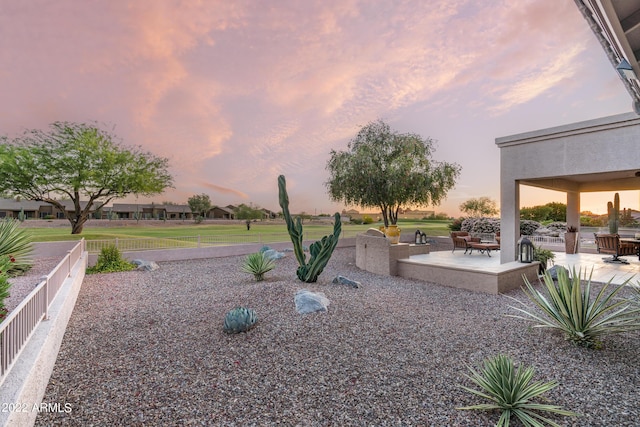 yard at dusk featuring a patio area