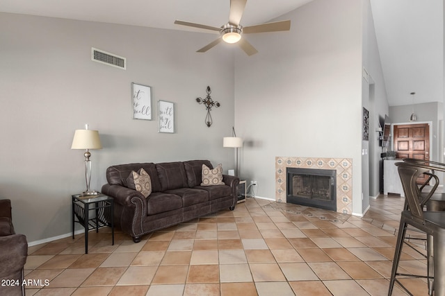 living room featuring a fireplace, high vaulted ceiling, ceiling fan, and light tile patterned floors