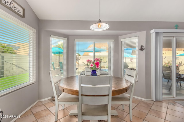 tiled dining area featuring vaulted ceiling and plenty of natural light