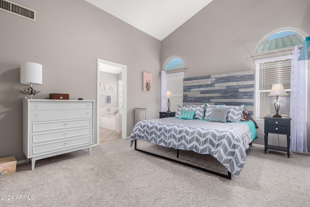 carpeted bedroom featuring connected bathroom and high vaulted ceiling