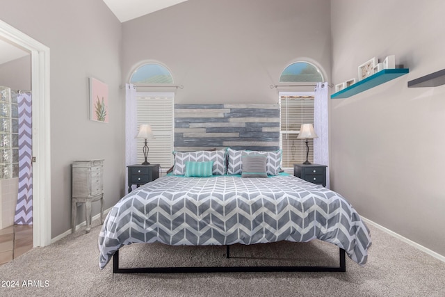 carpeted bedroom with high vaulted ceiling