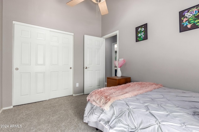 carpeted bedroom featuring a towering ceiling, a closet, and ceiling fan