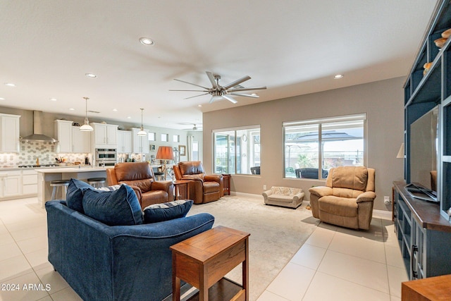 living room featuring light tile patterned floors, baseboards, a ceiling fan, and recessed lighting