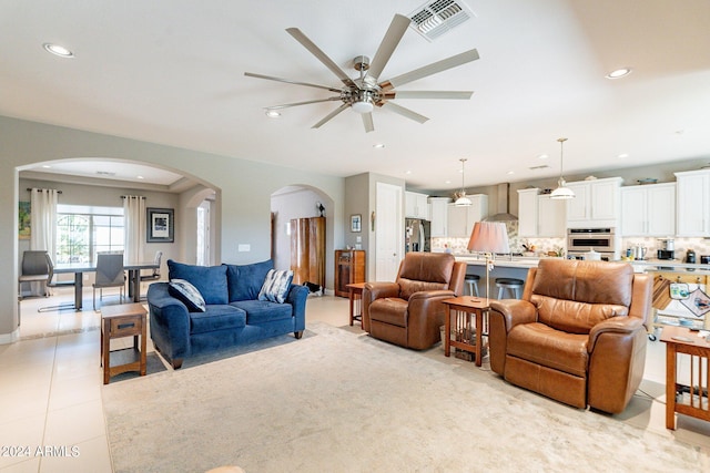 living area with arched walkways, ceiling fan, light tile patterned floors, recessed lighting, and visible vents