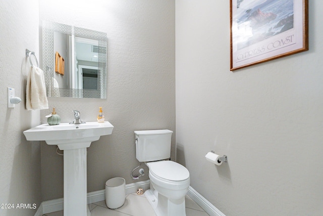 bathroom with tile patterned flooring, baseboards, and toilet