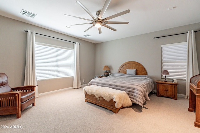 bedroom featuring light carpet, visible vents, and baseboards