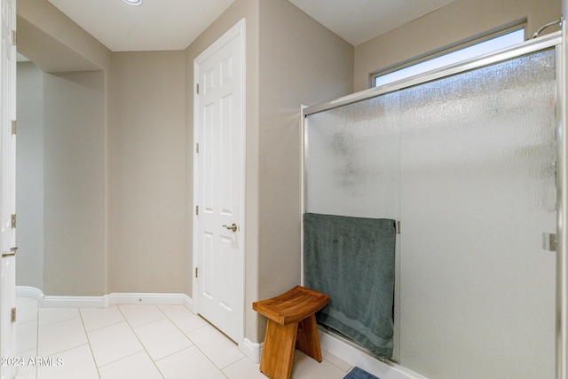 full bathroom with tile patterned floors, a shower stall, and baseboards