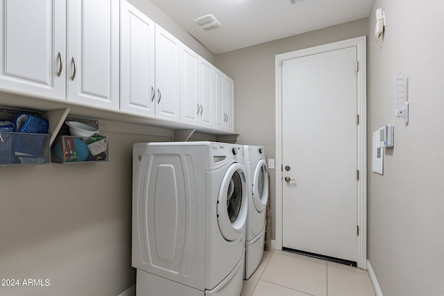 clothes washing area with cabinet space, light tile patterned floors, visible vents, baseboards, and independent washer and dryer