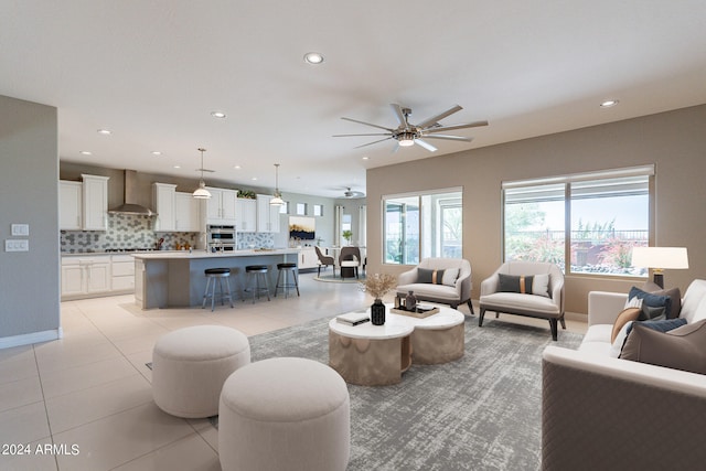 living room featuring light tile patterned floors, ceiling fan, baseboards, and recessed lighting