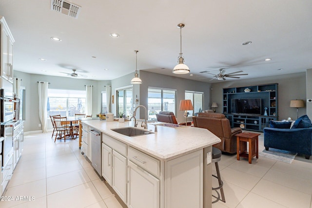 kitchen with sink, hanging light fixtures, appliances with stainless steel finishes, an island with sink, and a healthy amount of sunlight