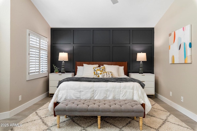9915 E Cinnabar Ave, Scottsdale, AZ 85258 - bedroom with lofted ceiling, a decorative wall, light wood finished floors, and baseboards