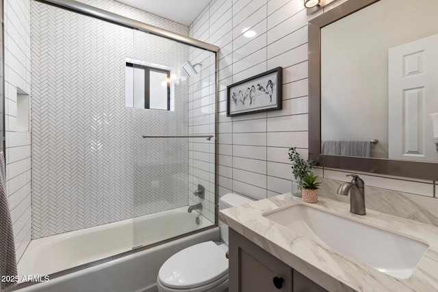 9915 E Cinnabar Ave, Scottsdale, AZ 85258 - full bathroom featuring vanity, toilet, bath / shower combo with glass door, and tile walls