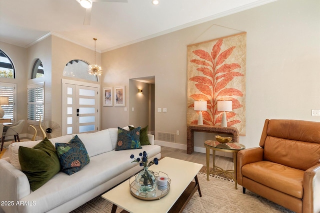 9915 E Cinnabar Ave, Scottsdale, AZ 85258 - living room featuring light wood finished floors, baseboards, visible vents, ceiling fan with notable chandelier, and ornamental molding