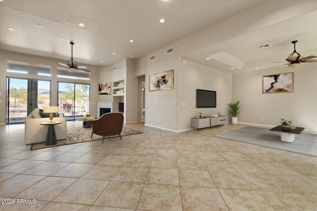 living room featuring ceiling fan, built in features, and light tile patterned floors