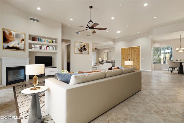 36908 N 19th St, Phoenix, AZ 85086 - living area with recessed lighting, a ceiling fan, built in features, a glass covered fireplace, and a chandelier