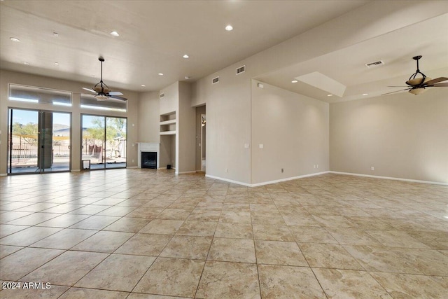 unfurnished living room featuring ceiling fan and built in features