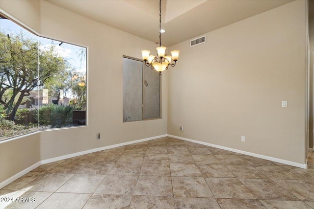 unfurnished room with a chandelier