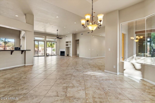 unfurnished living room with ceiling fan with notable chandelier