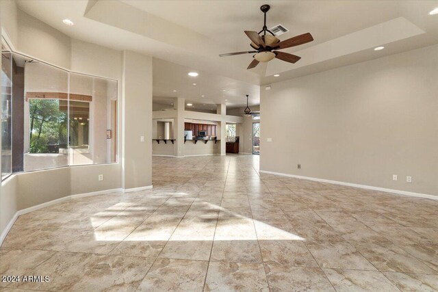 36908 N 19th St, Phoenix, AZ 85086 - unfurnished living room featuring ceiling fan, recessed lighting, baseboards, and a tray ceiling