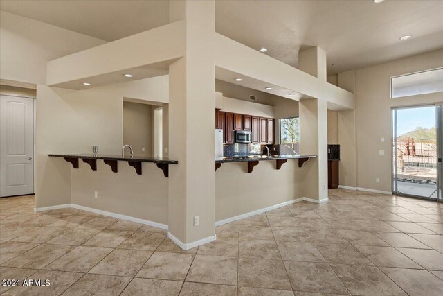 36908 N 19th St, Phoenix, AZ 85086 - kitchen featuring stainless steel microwave, a kitchen bar, recessed lighting, baseboards, and light tile patterned floors