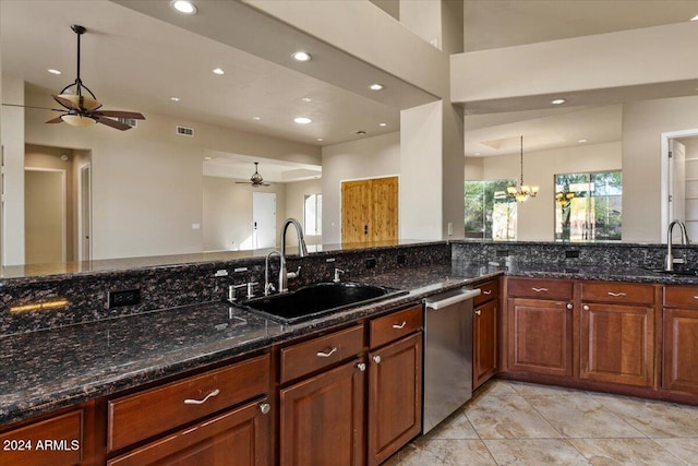 kitchen with dishwasher, dark stone counters, and sink