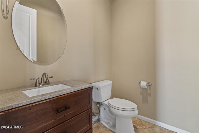 bathroom with tile patterned flooring, vanity, and toilet