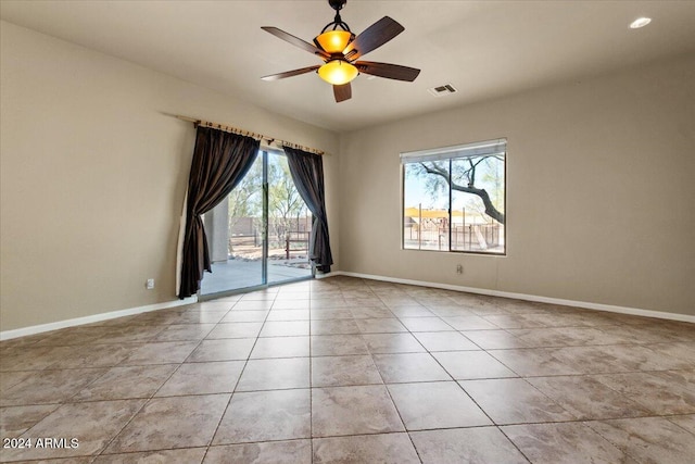 tiled empty room featuring ceiling fan