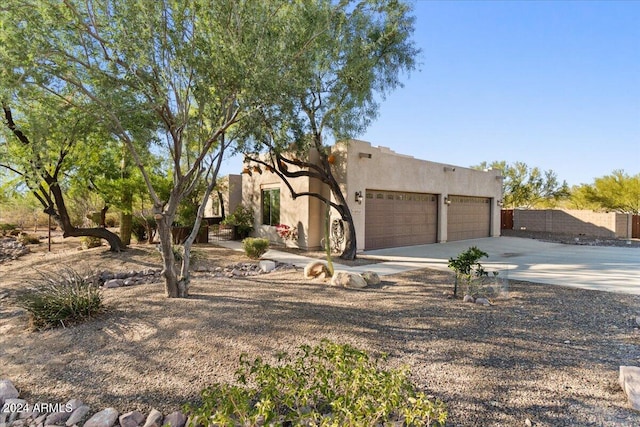 pueblo-style house featuring a garage