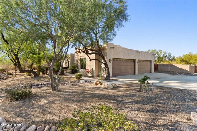 36908 N 19th St, Phoenix, AZ 85086 - pueblo revival-style home with an attached garage, stucco siding, and driveway