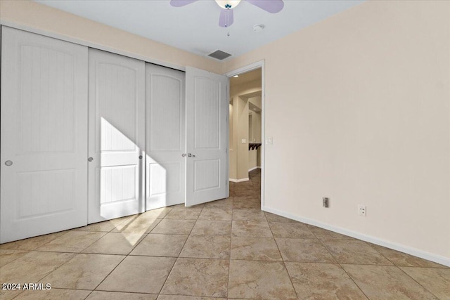 unfurnished bedroom with ceiling fan, light tile patterned flooring, and a closet