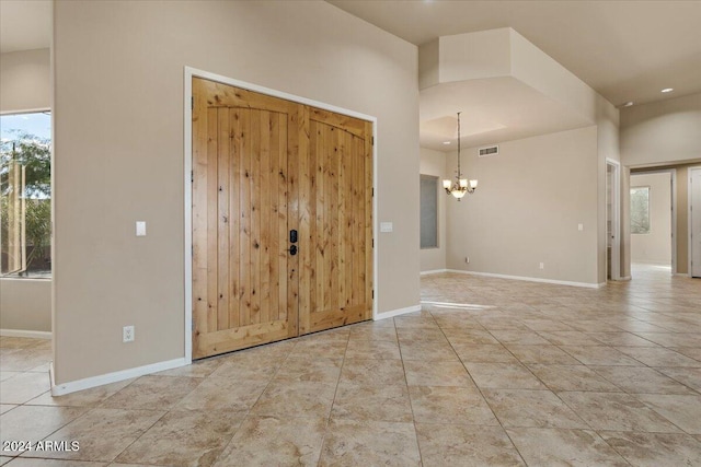 foyer entrance with light tile patterned floors and a notable chandelier