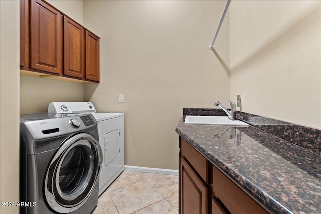 laundry area featuring cabinets, light tile patterned floors, separate washer and dryer, and sink