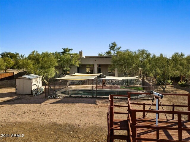 exterior space with a fenced in pool and a shed