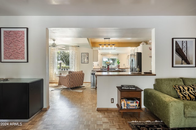 living room with ceiling fan with notable chandelier and light parquet flooring