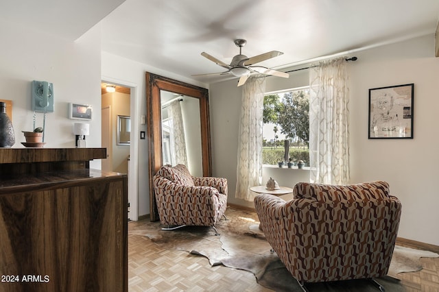 living area with ceiling fan and light parquet flooring