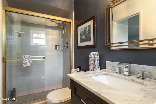 bathroom with an enclosed shower, vanity, and toilet