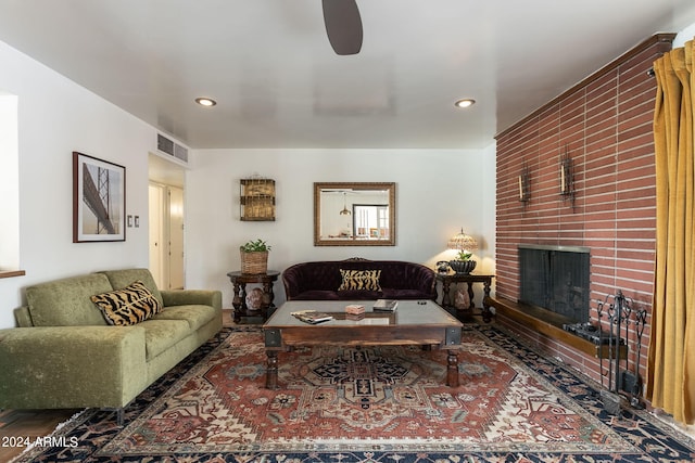 living room with ceiling fan and a fireplace