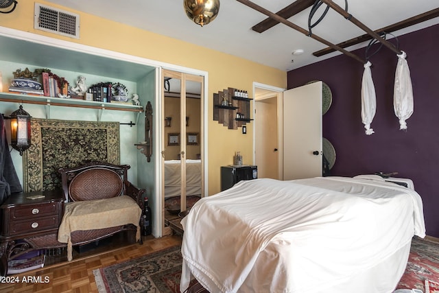 bedroom featuring dark parquet flooring and a closet